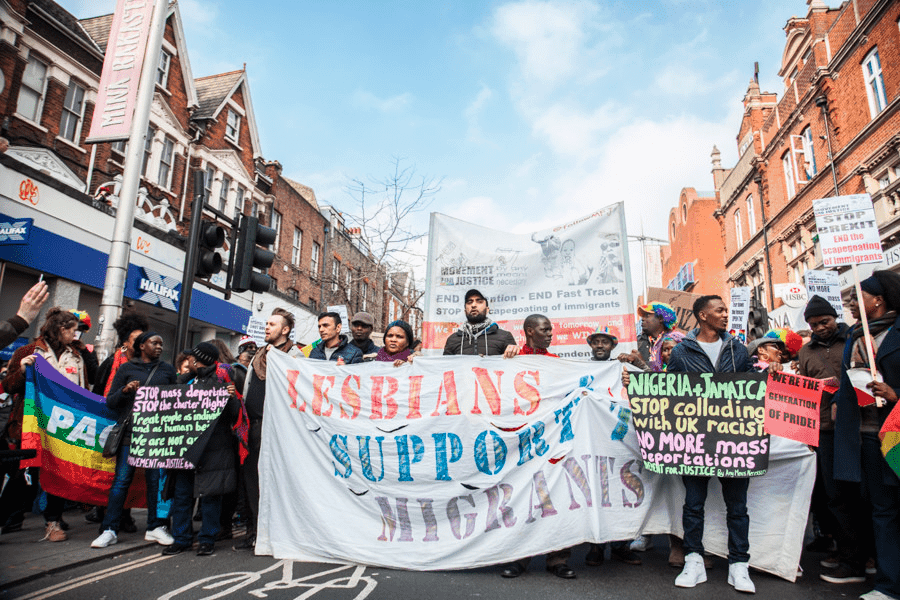 People with banner saying Lesbians Support The Migrants.
